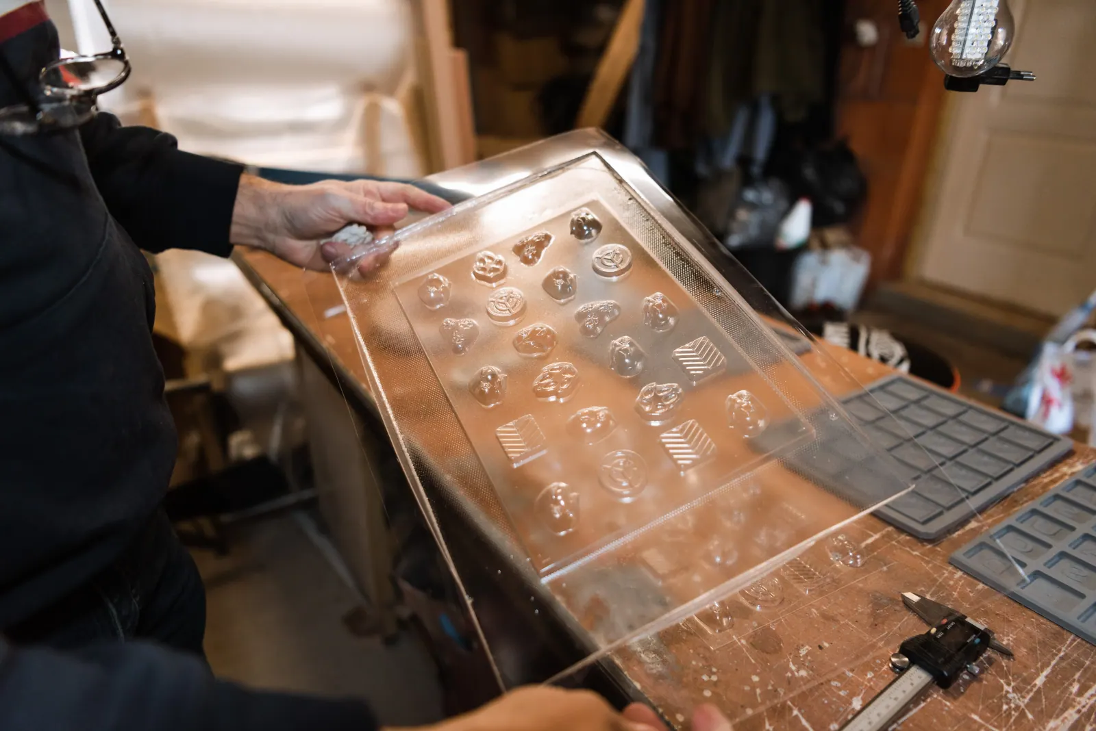 Plaque de moules chocolat personnalisés thermoformée, tenue à la main dans l’atelier